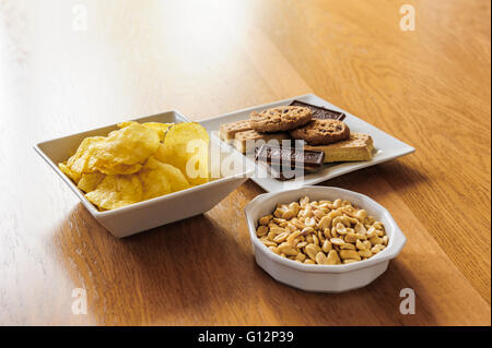 Schalen von Erdnüssen, Chips und Kekse. Stockfoto