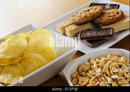 Schalen von Erdnüssen, Chips und Kekse. Stockfoto