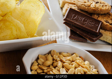 Schalen von Erdnüssen, Chips und Kekse. Stockfoto