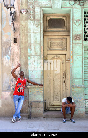 Zwei junge Männer vor einer hohen Tür in Alt-Havanna, Havanna, Kuba Stockfoto