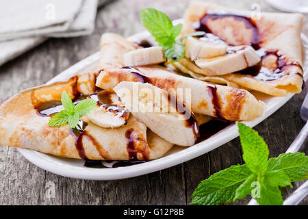 Hausgemachte französische Crepes mit Bananen und Schokolade Stockfoto