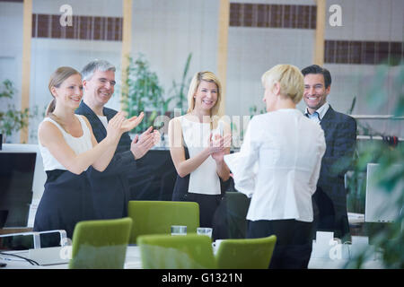 Glückliches Team von Geschäftsleuten im Büro geben Applaus Stockfoto