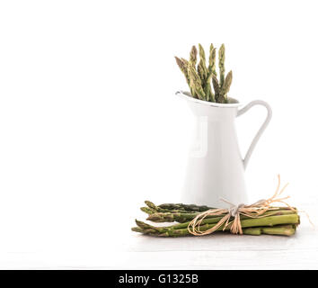 Frischer grüner Spargel im Krug auf alten weißen hölzernen Hintergrund Stockfoto