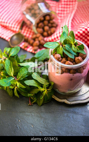 Schokolade Breakast Flakes mit Joghurt und Minze in Vintage Glas auf rustikalen Hintergrund Stockfoto