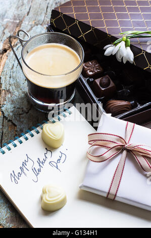 Geschenkbox und eine Tasse Kaffee mit Süßigkeiten auf rustikalen Tisch Stockfoto