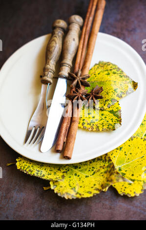 Herbstliche Tischdekoration mit Vintage Tisch Besteck und gelbe Blätter Stockfoto