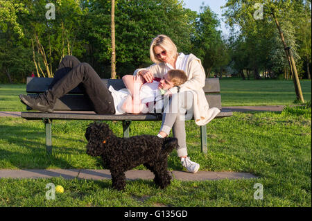 Mutter und Sohn auf einer Parkbank in London Stockfoto