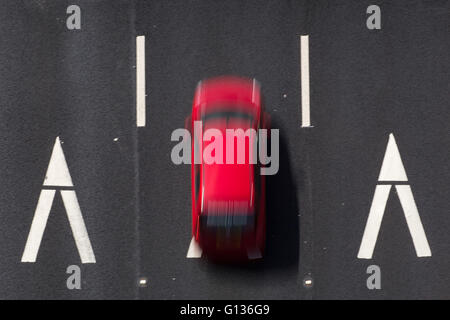 Ein rotes Auto fährt über ein Chevron-Schild auf der Autobahn M62, in der Nähe von Huddersfield, Yorkshire, England, am 4. Mai 2016. Stockfoto