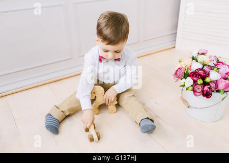 Junge beim Sitzen auf dem Boden spielen Stockfoto