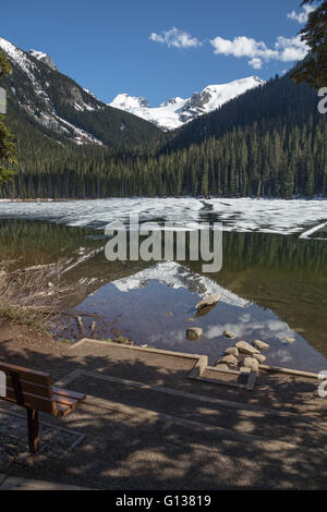 Schmelzender Schnee und Eis am Untersee Joffre aufzudecken Reflexionen auf Bäume, Berge und Gletscher Stockfoto