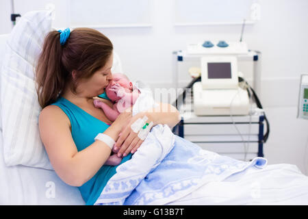 Mutter, die Geburt eines Babys. Neugeborenen im Kreißsaal. Mutter ihr neugeborenes Kind nach Arbeit zu halten. Stockfoto