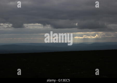 Verschiedene Schattierungen von blau und Sonnenstrahlen, die von einem schwedischen Berg gesehen. Stockfoto