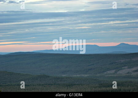 Verschiedene Schattierungen von blau und Orange über Waldlandschaft von einem schwedischen Berg gesehen. Stockfoto