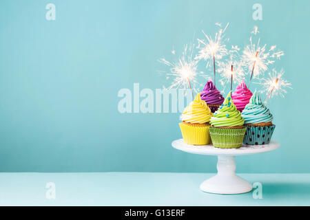 Muffins auf eine Tortenplatte mit Wunderkerzen Stockfoto