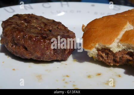 Gekochte Beefburger & eine halbe Brötchen gegessen Stockfoto