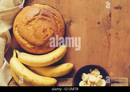 Hausgemachte Bananenbrot mit Schokolade und Erdnüssen auf hölzernen Hintergrund, Ansicht von oben Stockfoto