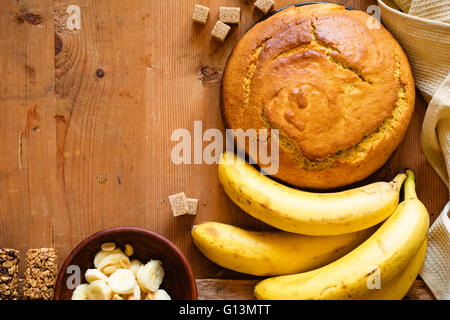 Hausgemachte Bananenbrot mit Schokolade und Erdnüssen auf hölzernen Hintergrund, Ansicht von oben Stockfoto