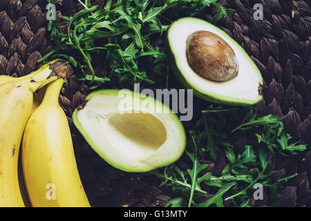 Bananen, Avocado und Rucola Blätter, Ansicht von oben. Frische Zutaten für einen grünen Smoothie detox vegane Vitamin drink Stockfoto