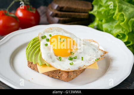 Sonnenseite, Ei, Avocado und Käse auf Vollkorn Toast für gesundes Frühstück Stockfoto