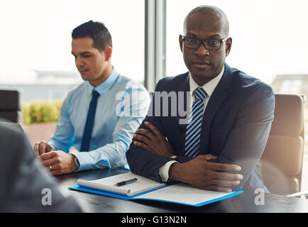 Exekutive multirassische Business-Team mit einem Treffen im Büro mit Fokus zu einem ernsthaften afroamerikanische Mann mittleren Alters-look Stockfoto