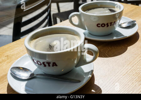 Zwei Tassen Kaffee auf einem Tisch in einem Zweig der Costa.  Zeigen das Costa-Logo auf den Cups. Das Unternehmen ist im Besitz von Whitbread. Stockfoto