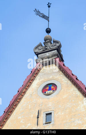 Glasfenster und Windfahne auf dem Dach des mittelalterlichen Hauses. Jetzt Gebäude von Tallinn City Theater Stockfoto