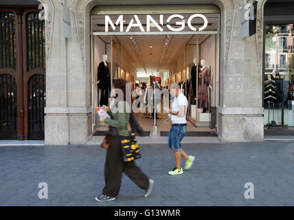 Leute gehen vorbei an einem Mango Shop / store in Passeig de Gracia, Barcelona, Spanien Stockfoto