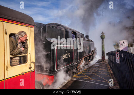 Mann sucht aus Wagen Fenster bei Dampf Pickering Station, North Yorkshire Moors Railway, England, UK Zuges. Fokus liegt Stockfoto