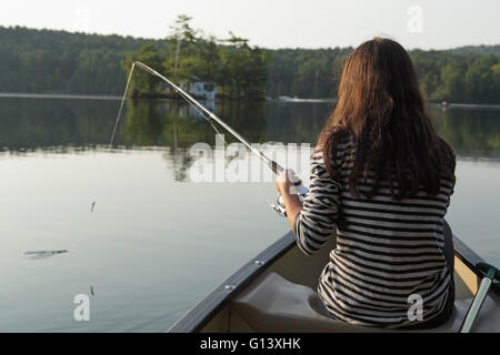 Junges Mädchen Angeln vom Kanu in einem See im westlichen Vermont Stockfoto