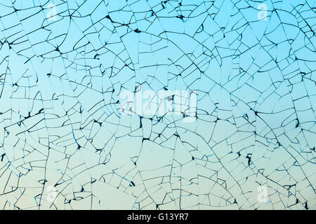 Zerbrochenes Glas-Textur mit Rissen auf blauem Hintergrund Stockfoto