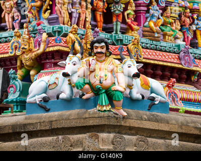 Malte Schnitzereien von einem indischen Idol mit heiligen Kühe vor einer Wand von Statuen am Kapaleeshwarar Tempel, Mylapore, Chennai Stockfoto