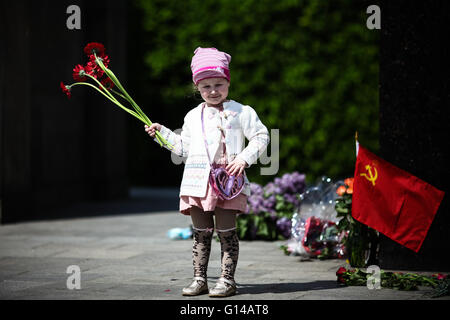 Berlin, Deutschland. 8. Mai 2016. Eine Mädchen hält Blumen an das Sowjetische Ehrenmal im Tiergarten Bezirk von Berlin, Deutschland, am 8. Mai 2016. Menschen in Deutschlands Hauptstadt Berlin versammelten sich am Sonntag anlässlich der 71. Jahrestag des Endes des zweiten Weltkriegs. © Zhang Fan/Xinhua/Alamy Live-Nachrichten Stockfoto