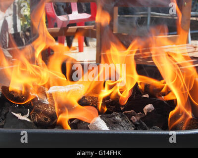 brennende Holzkohle mit Flammen auf einem Grill Stockfoto