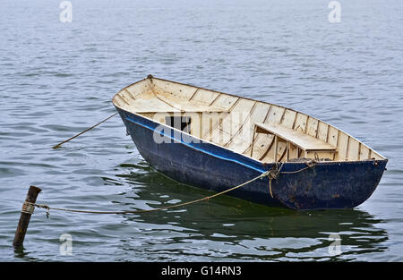 Kleine schwimmende Boot am Ufer des Sees verankert Stockfoto