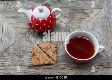 Rooibos Tee mit zwei Tee-Keks und eine Teekanne, alle auf einem geborgenen Holztisch. Stockfoto