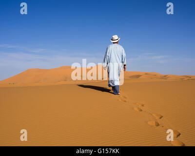 Mann allein zu Fuß unter den Sanddünen der Sahara. Best of Marokko Stockfoto