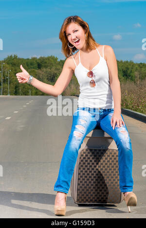 fröhliches Mädchen schöne Fänge einem vorbeifahrenden Auto Stockfoto