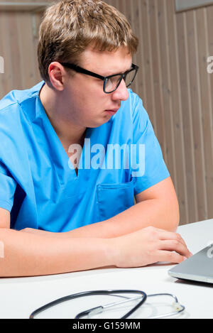 Porträt von nachdenklich Arzt in Gläser in blau medizinische uniform Stockfoto