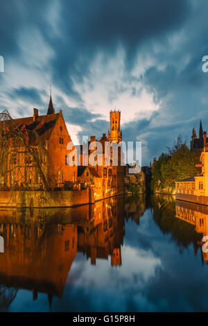 Rozenhoedkaai mit Glockenturm am Dijver Kanal nach Sonnenuntergang in Brügge, Belgien Stockfoto