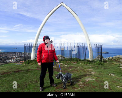 Mann mit Hund stand vor Walknochen an Spitze des North Berwick rechts Stockfoto