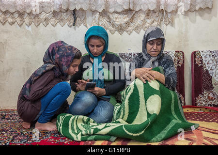 Großmutter, Mutter und Tochter mit Handy in ihre ländliche Heimat im Jandab, Iran. Stockfoto