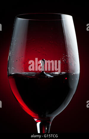 Rot Wein Tropfen in ein Glas Spritzen Stockfoto