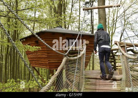 Witzenhausen, Deutschland. 29. April 2016. Geschäftsführer Peter Becker überquert eine Hängebrücke auf seinem Weg zum Haupthaus der Baumhaus Herberge in der Nähe von Witzenhausen, Deutschland, 29. April 2016. Foto: UWE ZUCCHI/Dpa/Alamy Live News Stockfoto