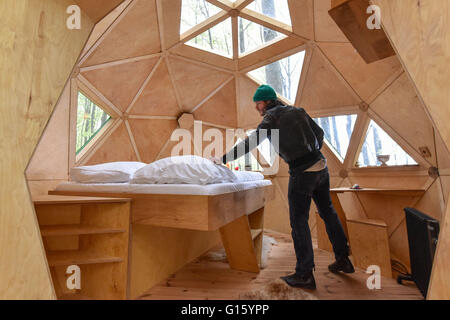 Witzenhausen, Deutschland. 29. April 2016. Geschäftsführer Peter Becker ordnet das Bett in der Baumhaus-Kugel befindet sich in einem Wald in der Nähe von Witzenhausen, Deutschland, 29. April 2016. Foto: UWE ZUCCHI/Dpa/Alamy Live News Stockfoto