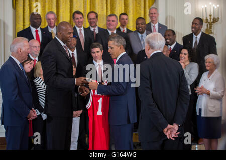 Washington, DC, USA. 9. Mai 2016. US-Präsident Barack Obama, mit Vizepräsident Joseph Biden (L) erhält eine Trikot von Thurl Bailey (2 L) nach der Begrüßung ehemaliger Spieler und Trainerstab der 1983 NCAA National Basketball Championship North Carolina State Wolfpack im East Room des weißen Hauses in Washington, DC, USA, 9. Mai 2016. Der Präsident und Vizepräsident traf kurz mit den Mitgliedern des Teams und ihre Familien im östlichen Raum. Das Team war zuvor nicht möglich war, das Weiße Haus anerkannt zu werden für ihre Meisterschaft zu besuchen. Bildnachweis: Dpa picture Alliance/Alamy Live News Stockfoto