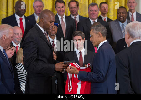 Washington, DC, USA. 9. Mai 2016. US-Präsident Barack Obama erhält eine Trikot von Thurl Bailey (L) nach der Begrüßung ehemaliger Spieler und Trainerstab der 1983 NCAA National Basketball Championship North Carolina State Wolfpack im East Room des weißen Hauses in Washington, DC, USA, 9. Mai 2016. Der Präsident und Vizepräsident traf kurz mit den Mitgliedern des Teams und ihre Familien im östlichen Raum. Das Team war zuvor nicht möglich war, das Weiße Haus anerkannt zu werden für ihre Meisterschaft zu besuchen. Bildnachweis: Dpa picture Alliance/Alamy Live News Stockfoto