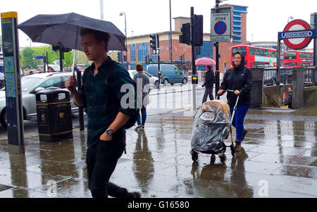 London, UK. 10. Mai 2016. Kunden und Arbeitnehmer mit Sonnenschirmen im Norden von London an einem regnerischen Tag. Bildnachweis: Dinendra Haria/Alamy Live-Nachrichten Stockfoto