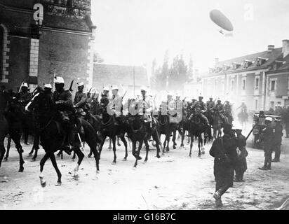 Französische Soldaten auf dem Pferderücken in der Straße, mit einem Luftschiff fliegen in Luft dahinter während Weltkrieg I. Kavallerie oder Reiter waren Soldaten oder Krieger gekämpft montiert auf dem Pferderücken. Ein Soldat in der Kavallerie ist durch eine Reihe von Bezeichnungen wie Cava bekannt. Stockfoto