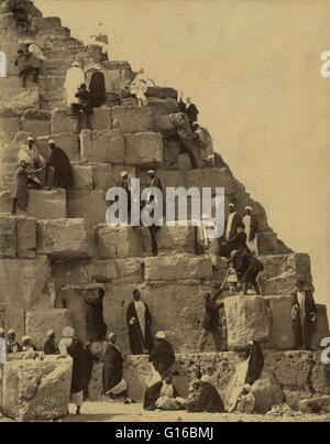 Unter dem Titel: "mehrere Personen versammelten sich am Fuße der großen Pyramide, andere Klettern". Die große Pyramide von Giza (auch bekannt als die Pyramide von Khufu oder der Pyramide des Cheops) ist die älteste und größte der drei Pyramiden in Gizeh Nekropole an der Grenze Stockfoto
