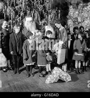 Titel: "Grace Coolidge, Santa Claus und Kinder neben Weihnachtsbaum." Grace Anna Goodhue Coolidge (3. Januar 1879 - 8. Juli 1957) war die Ehefrau von Calvin Coolidge und First Lady der Vereinigten Staaten von 1923 bis 1929. Sie ist Absolventin der Universität Stockfoto